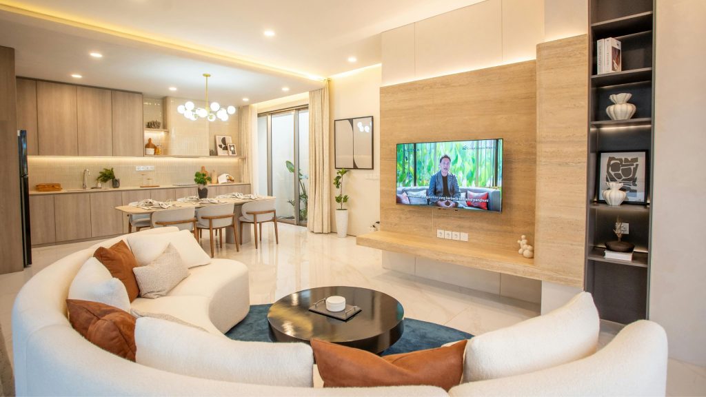 An open-plan Sydney living room with a timber TV feature wall, floating shelf and dark display shelving tower, fitted to the millimeter by 10X Joinery.