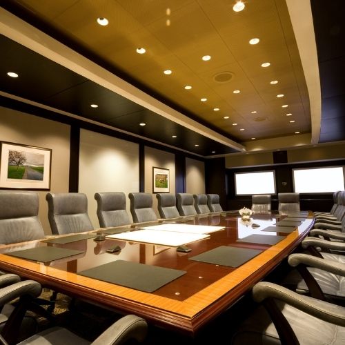 A long timber boardroom table with executive seating in an Auburn office, crafted by 10X Joinery.