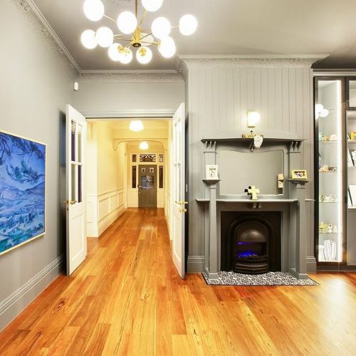 Renovated period home hallway with custom built-in cabinetry beside a fireplace