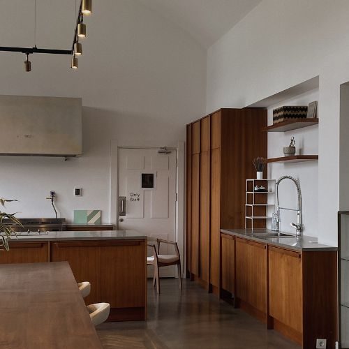 Walnut timber kitchen cabinetry with a full-height pantry and stainless benchtop, made and fitted for an Auburn home by 10X Joinery.