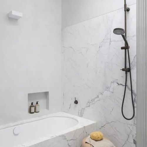 Marble-look bathroom with built-in bath and shower niche by 10X Joinery Sydney