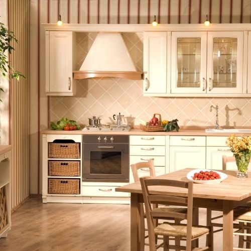 A classic cream country-style kitchen with glass-front cabinets and wicker basket drawers, typical of older Baulkham Hills homes ready for an update by 10X Joinery.