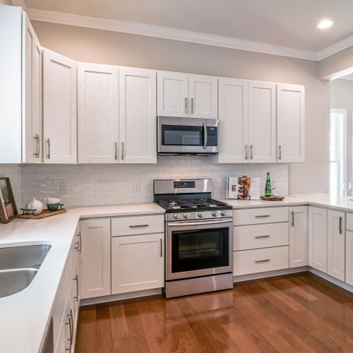A spacious white L-shaped kitchen with generous bench space and deep drawers, built for a busy Blacktown family by 10X Joinery.