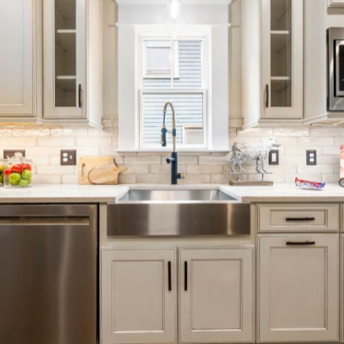 White shaker kitchen cabinetry with glass-front overheads and a farmhouse sink, made locally in our Castle Hill workshop by 10X Joinery.