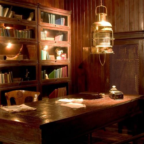 A combined home office and library in Sydney with dark timber glass-front bookcases and a solid timber desk by 10X Joinery.