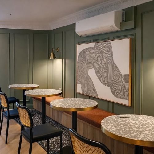 Commercial cafe fit-out by 10X Joinery Sydney with green panelled walls and banquette seating
