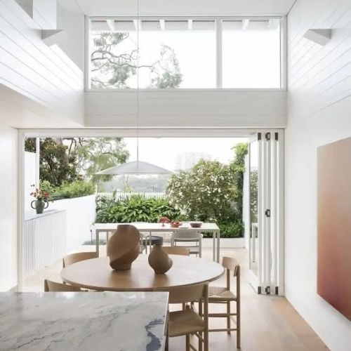 Bright open dining space with bifold doors and custom joinery fit-out