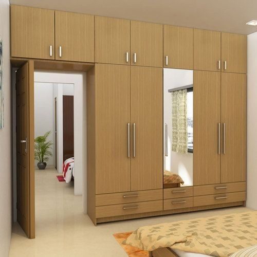 A custom timber-grain wardrobe with a mirrored door, overhead cupboards and drawers, built to fit a Sydney bedroom by 10X Joinery.