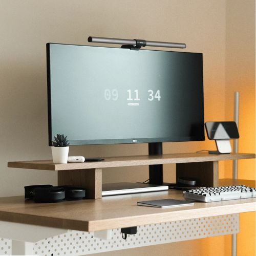 A timber desk with a monitor riser and under-desk cable management panel, keeping a Sydney home office tidy, by 10X Joinery.