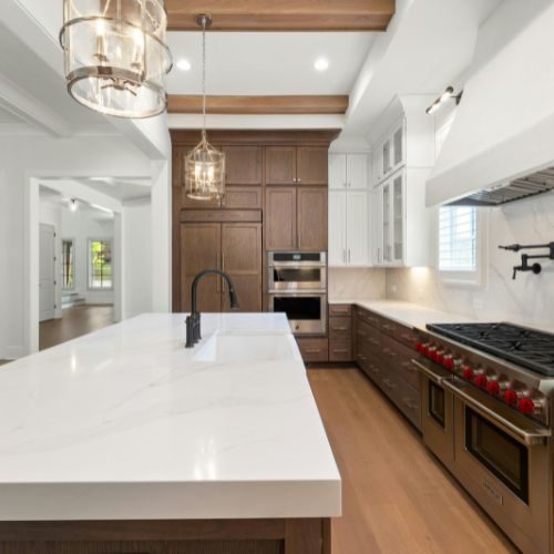 A Blacktown kitchen with a white marble-look island and splashback coordinated with timber cabinetry, installed by 10X Joinery.